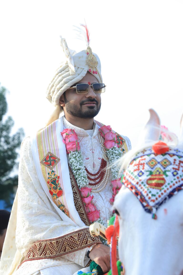 Indian groom in traditional attire on a beautifully adorned horse in Gondal.